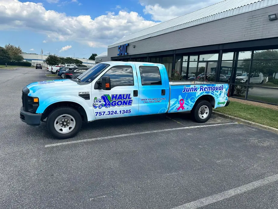 Haul Gone pickup with the company wrap and phone number on the door